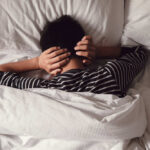 Yoga Beats Ambien? Bedtime Stretching’s Secret Child lying in bed with hands over ears