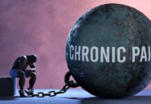 A figure representing chronic pain, sitting beside a large ball labeled 'CHRONIC PAIN' chained to their body