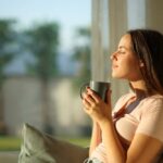 Woman enjoying a cup of coffee in a sunlit room