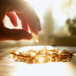 A hand reaching for a golden capsule among many on a table