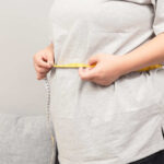 Mayo Clinic Uncovers Hidden Weight Loss Power Combo Person measuring their waist with a tape measure