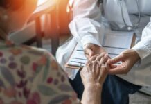 Hidden Viruses Linked To Inflammation A doctor holding the hand of an elderly patient during a consultation