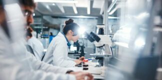 Scientists working in a laboratory with microscopes and test tubes