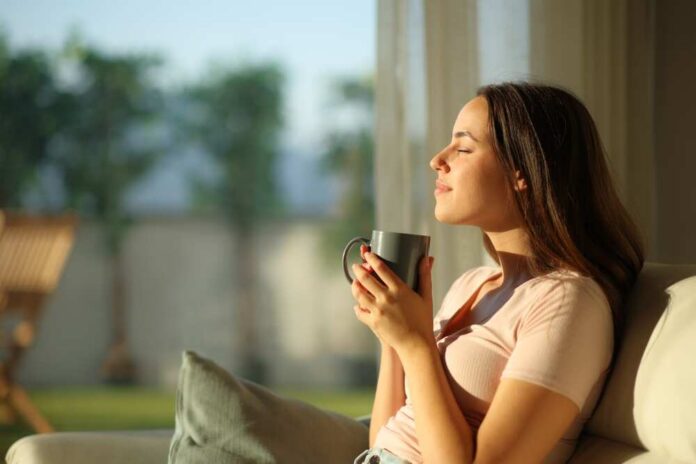 Woman enjoying a cup of coffee in a sunlit room