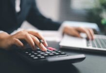 Desk Workers’ Secret WEAPON Against Health Risks A business professional using a calculator while working on a laptop